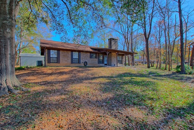 back of property with central air condition unit and a yard