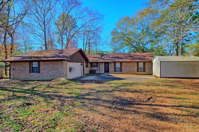 rear view of property with a lawn and a storage shed