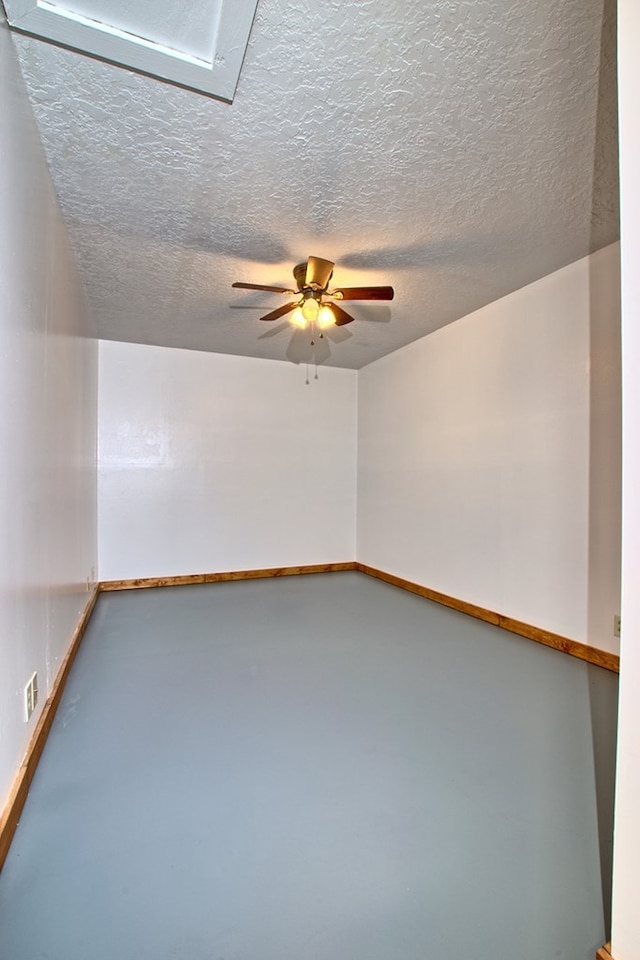 unfurnished room featuring ceiling fan, a textured ceiling, and concrete floors