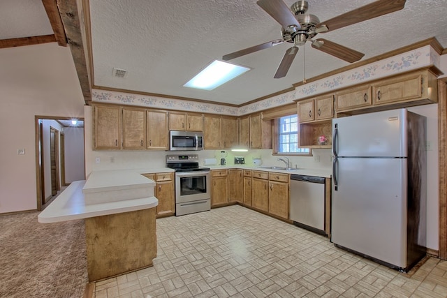 kitchen featuring kitchen peninsula, a textured ceiling, stainless steel appliances, ceiling fan, and sink