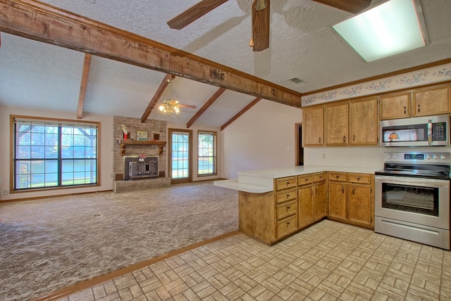 kitchen with kitchen peninsula, appliances with stainless steel finishes, a textured ceiling, vaulted ceiling with beams, and a wood stove