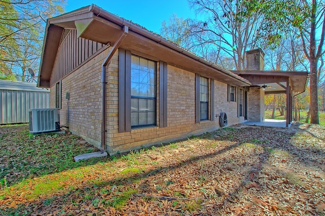 view of side of home featuring cooling unit and ceiling fan