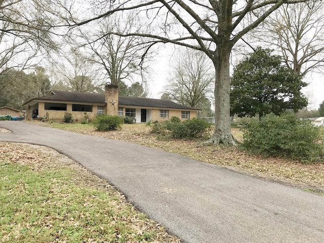 ranch-style house featuring a chimney