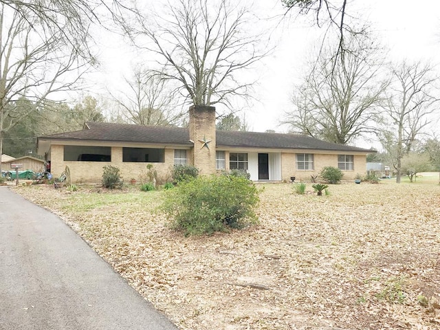 single story home with brick siding and a chimney