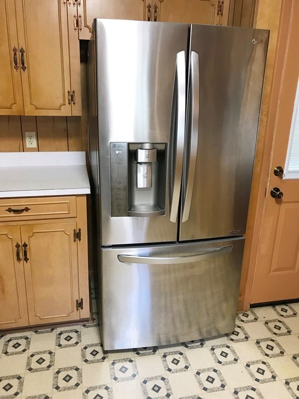 kitchen featuring light floors, light countertops, brown cabinets, and stainless steel fridge with ice dispenser