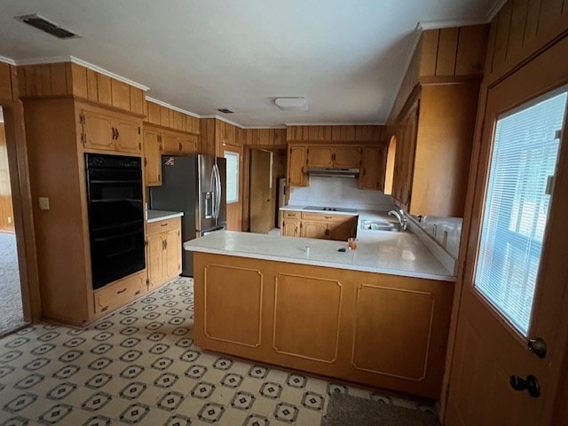 kitchen with visible vents, ornamental molding, dobule oven black, under cabinet range hood, and light countertops