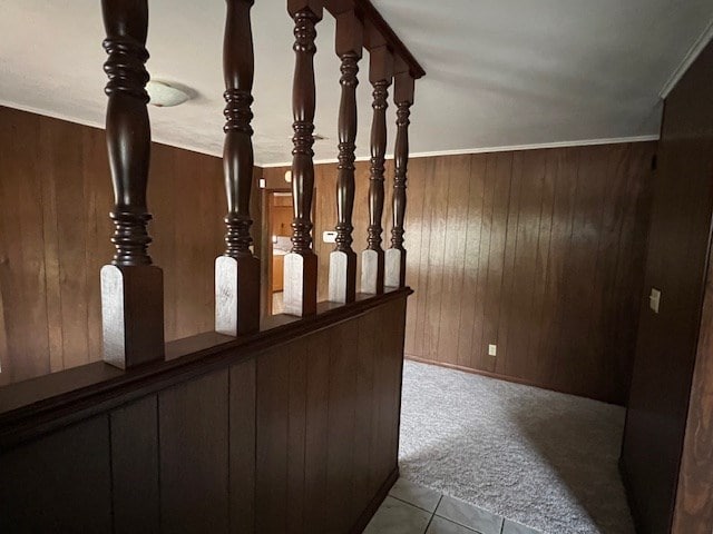 staircase featuring carpet, wood walls, tile patterned flooring, and ornamental molding