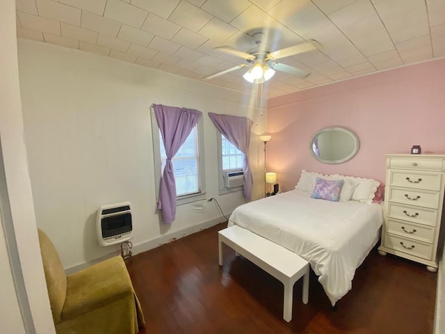 bedroom featuring heating unit, ceiling fan, and dark hardwood / wood-style floors