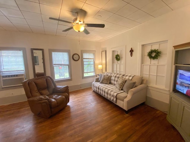 living room featuring built in shelves, ceiling fan, dark hardwood / wood-style flooring, and a healthy amount of sunlight