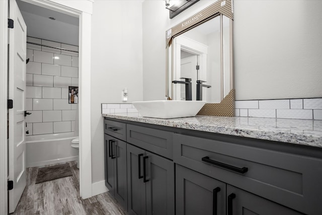 full bathroom featuring vanity, toilet, tiled shower / bath combo, and wood-type flooring