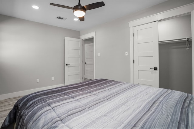 bedroom featuring light hardwood / wood-style flooring, ceiling fan, and a closet