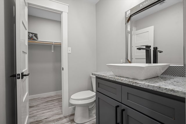 bathroom featuring vanity, hardwood / wood-style floors, and toilet