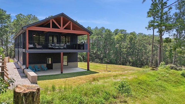 back of property with a lawn and a patio area