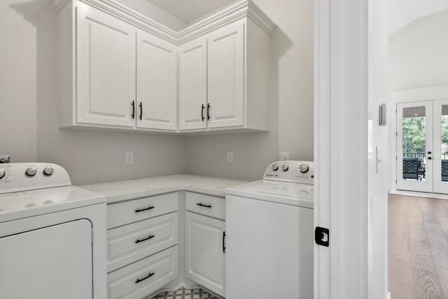 clothes washing area with washing machine and dryer, french doors, cabinets, and light hardwood / wood-style flooring