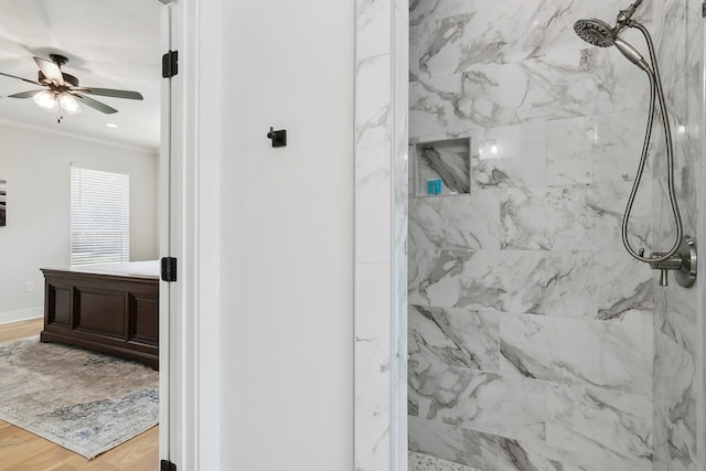 bathroom featuring tiled shower, hardwood / wood-style floors, ceiling fan, and ornamental molding