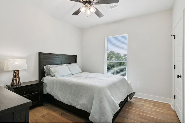 bedroom with dark hardwood / wood-style floors and ceiling fan