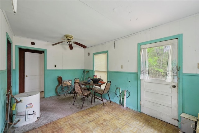 dining space with a wainscoted wall and ceiling fan