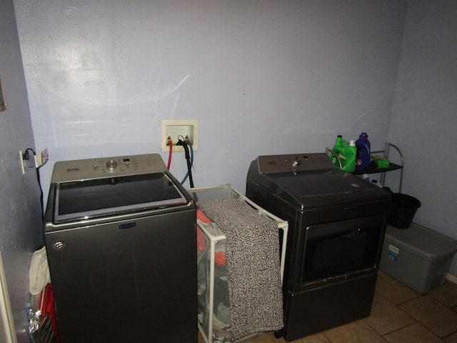 laundry area with independent washer and dryer and tile patterned floors