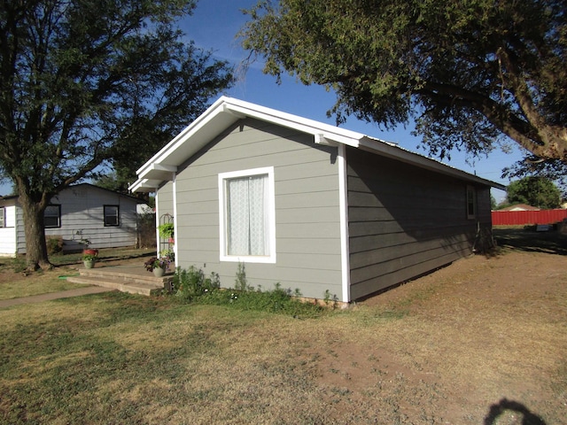 view of side of home with a yard