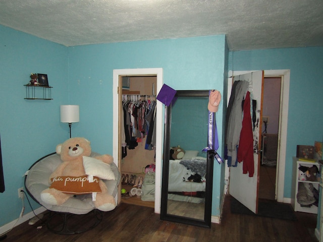 bedroom with a textured ceiling and dark wood-type flooring