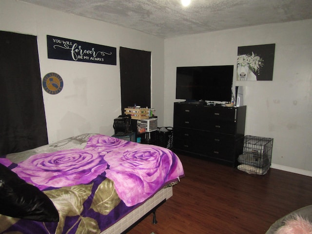 bedroom featuring dark hardwood / wood-style floors and a textured ceiling