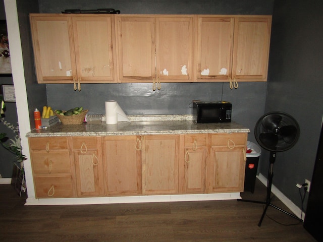 kitchen with tasteful backsplash, light stone countertops, light brown cabinets, and dark wood-type flooring