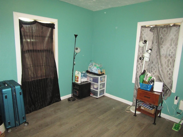 miscellaneous room with a textured ceiling and dark wood-type flooring