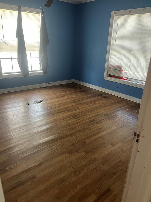 empty room with baseboards and wood finished floors