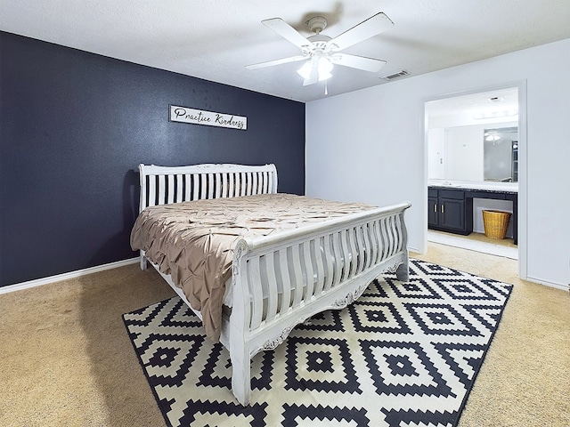 bedroom featuring ceiling fan, light carpet, and ensuite bath