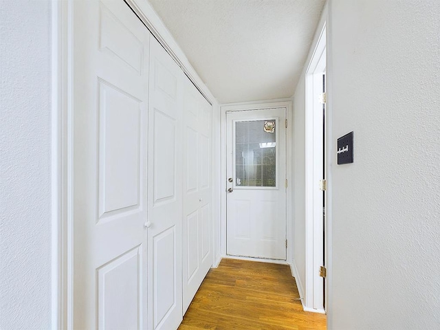 hallway featuring wood-type flooring and a textured ceiling