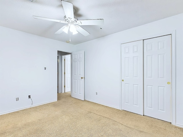 unfurnished bedroom featuring light carpet, a closet, and ceiling fan