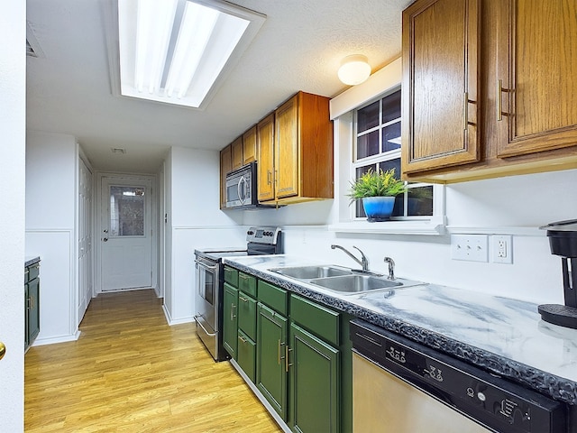 kitchen with sink, stainless steel appliances, and light hardwood / wood-style floors