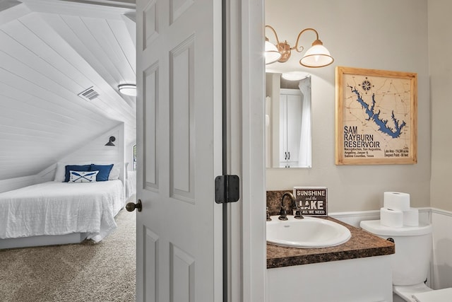 ensuite bathroom with visible vents, toilet, connected bathroom, vaulted ceiling, and vanity