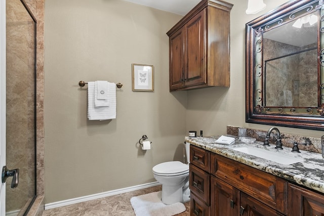 full bathroom with toilet, a shower stall, baseboards, and vanity