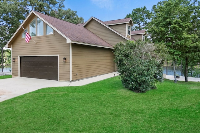 view of home's exterior featuring a shingled roof, concrete driveway, and a yard