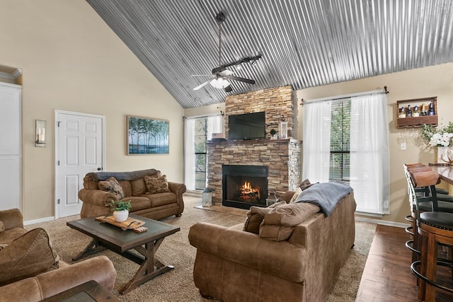 living area with high vaulted ceiling, dark wood finished floors, plenty of natural light, and a stone fireplace