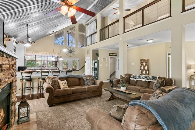 living area featuring high vaulted ceiling, ceiling fan, a fireplace, and ornamental molding