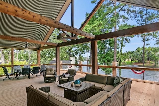 wooden terrace featuring outdoor dining space, outdoor lounge area, ceiling fan, and a water view