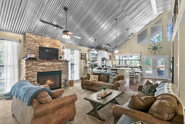 living area featuring ceiling fan, high vaulted ceiling, a fireplace, and track lighting