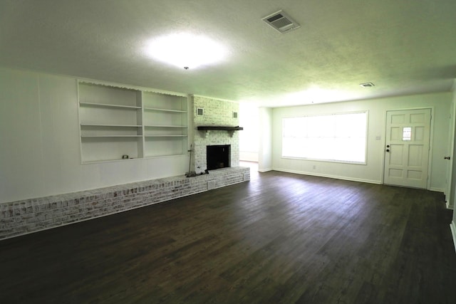 unfurnished living room with dark hardwood / wood-style flooring, a fireplace, and a textured ceiling