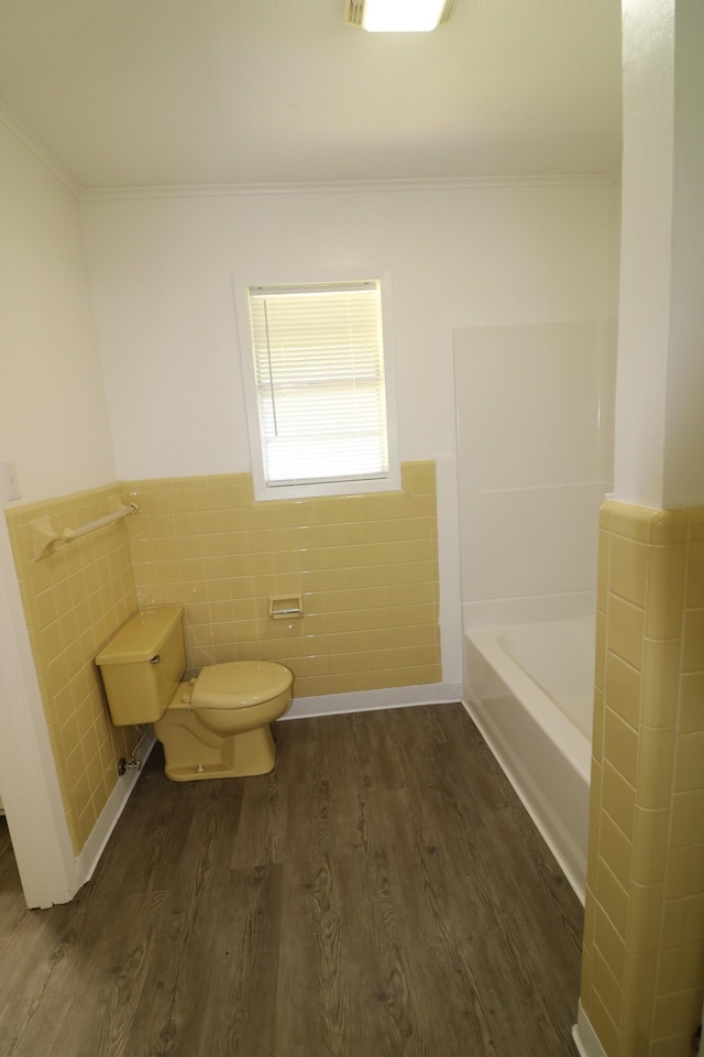 bathroom featuring hardwood / wood-style floors, toilet, tile walls, and a bathing tub