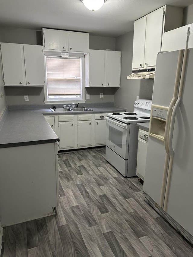 kitchen with white cabinetry, white appliances, and dark hardwood / wood-style floors