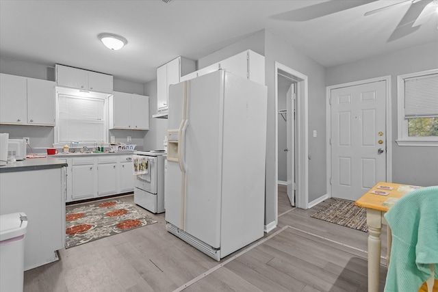 kitchen with white appliances, sink, light wood-type flooring, and white cabinets