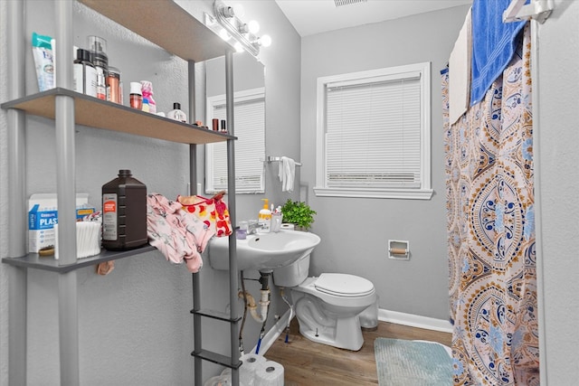 bathroom with hardwood / wood-style flooring, toilet, sink, and a shower with shower curtain