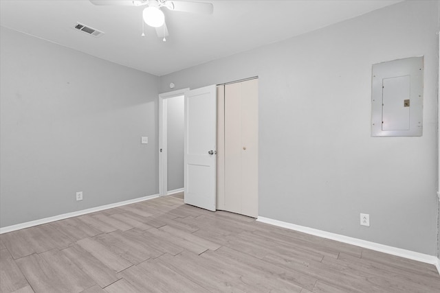 unfurnished bedroom featuring electric panel, a closet, ceiling fan, and light wood-type flooring