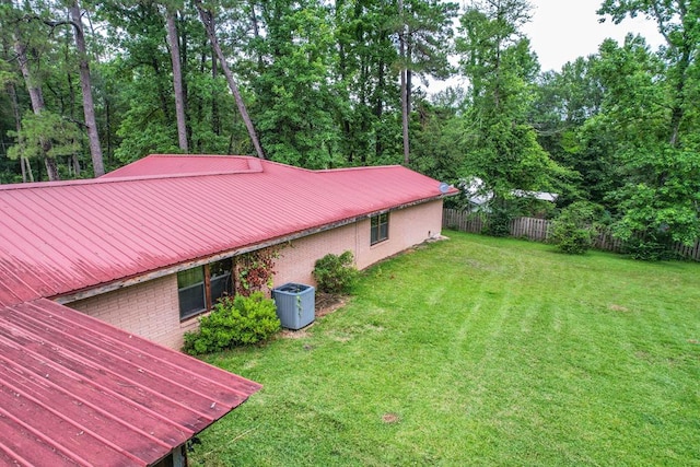 303 W Stringer, Kirbyville, TX 75956 - view of side of home featuring brick siding, metal roof, and central AC