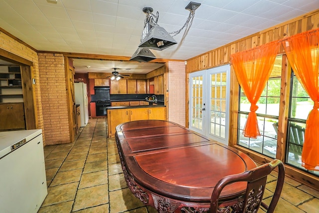 303 W Stringer, Kirbyville, TX 75956 - dining area with french doors, brick wall, wood walls, and ceiling fan