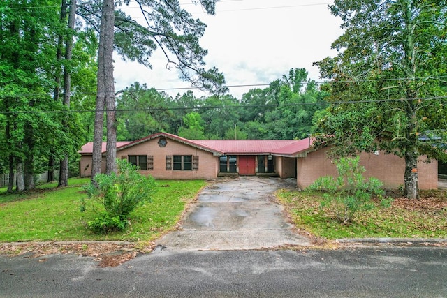 303 W Stringer, Kirbyville, TX 75956 - ranch-style house with concrete driveway, a front lawn, and metal roof