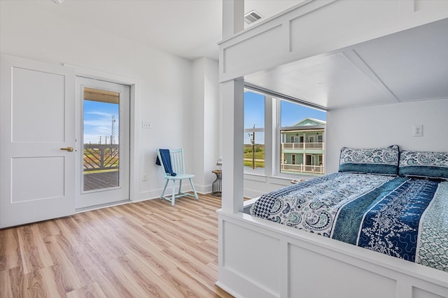 bedroom with visible vents, baseboards, access to outside, and light wood-style floors