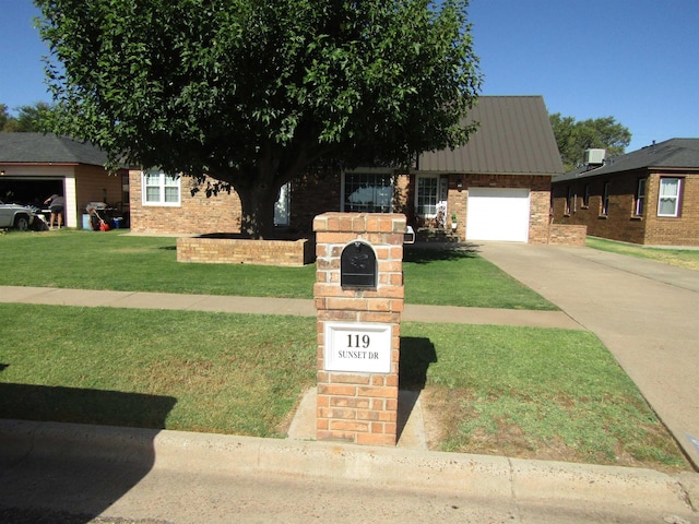 view of front of property featuring a garage and a front lawn